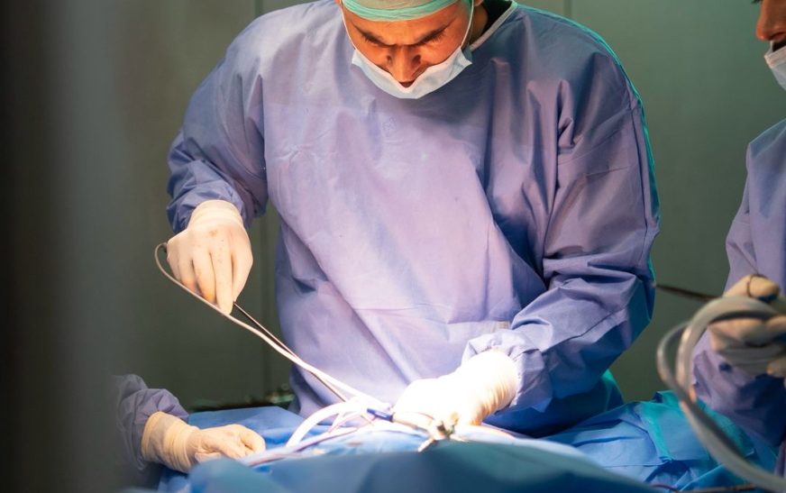 Bariatric surgeon performing a procedure in an operating room, representing medical and surgical treatment options for obesity.